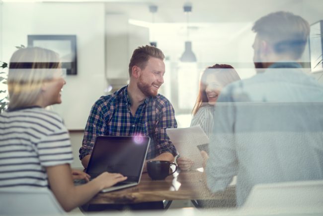 Team of happy entrepreneurs talking on a business meeting in the office.
